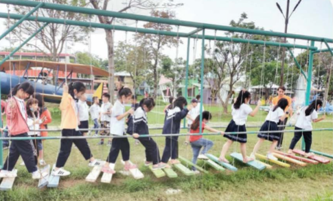 A group of children playing on a swing

Description automatically generated