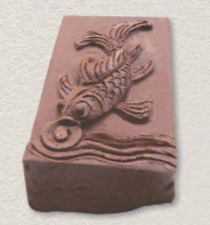 A brown brick with a fish carved on it

Description automatically generated