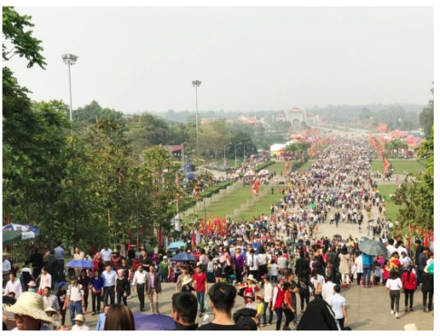 A large crowd of people walking down a street

Description automatically generated