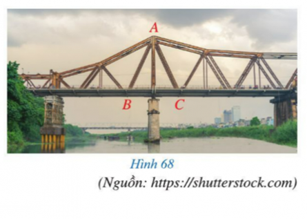 BÀI 7: TAM GIÁC CÂNKhởi độngCâu hỏi: Hai thanh giằng của cầu Long Biên bắc qua sông Hồng ở Thủ đô Hà Nội (hình 68) gợi nên hình ảnh tam giác ABC có sự đối xứng và cân bằng. Tam giác ABC như vậy gọi là tam giác gì?Trả lời rút gọn:Tam giác ABC như vậy gọi là  tam giác cân.I. Định nghĩaBài 1: Trong hình 69, hai cạnh AB và AC của tam giác ABC có bằng nhau hay không?Trả lời rút gọn:Ta có: AB và AC là đường chéo của hai hình chữ nhật có kích thước 2 và 4 ô vuông. Do đó AB = AC.II. Tính chấtBài 1: Cho tam giác ABC cân tại A, tia phân giác của góc A cắt cạnh BC tại D (hình 72)a. Hai tam giác ABD và ACD có bằng nhau hay không? Vì sao?b. Hai góc B và C có bằng nhau hay không? Vì sao?Trả lời rút gọn:a) Tam giác ABC cân tại A nên AB = AC.AD là tia phân giác góc  có:.Xét  và  có:AB = ACAD chung.Suy ra b) Do  nên .III. Dấu hiệu nhận biếtBài 1: Cho tam giác ABC thỏa mãn . Kẻ AH vuông góc với BC, H thuộc BC (hình 74)a. Hai tam giác BAH và CAH có bằng nhau hay không? Vì sao?b. Hai cạnh AB và AC có bằng nhau hay không? Vì sao?Trả lời rút gọn:Do AH  BC nên tam giác AHB và tam giác AHC là hai tam giác vuông tại H.Xét  vuông tại H có:  Do đó: Xét vuông tại H có: Do đó: Mà  (giả thiết) Suy ra .Xét  vuông tại H và  vuông tại H có: (chứng minh trên).AH chungSuy ra  (góc nhọn – cạnh góc vuông).b) Do  (theo a) nên AB = AC.Bài 2: Cho tam giác ABC cân tại A. Qua điểm M nằm giữa A và B kẻ đường thẳng song song với BC cắt AC tại N. Chứng minh tam giác AMN cân.Trả lời rút gọn:Tam giác ABC cân tại A nên .Do MN // BC nên  (2 góc đồng vị) và .Mà  nên Tam giác AMN có  nên tam giác AMN cân tại A.Vậy tam giác AMN cân tại A.IV. Vẽ tam giác cânV. Bài tập